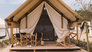 Safari tent Glamping Comfort met privé sanitaire, houten terras en gezellige buitenzitplaatsen.