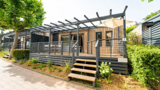 Modern lodge at Next L EVO with wood paneling, covered terrace, garden space, and bright natural light.