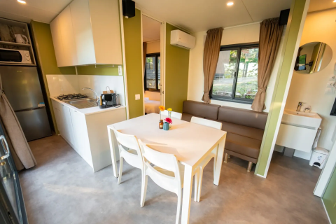 Modern lodge-interieur met keuken, eettafel en bank bij Next L EVO, Vacanze Glamping Boutique in Italië.