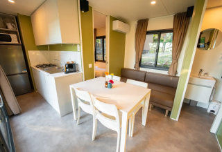 Modern lodge-interieur met keuken, eettafel en bank bij Next L EVO, Vacanze Glamping Boutique in Italië.