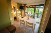 Interior of Next L EVO lodge at Vacanze Glamping Boutique Italy, featuring dining table and outdoor patio.