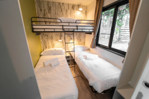 Driepersoonskamer met twee eenpersoonsbedden en stapelbed bij Next L EVO, Vacanze Glamping Boutique, Italië.