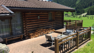Schöneben Chalet Bergkristall med træterrasse, bjergudsigt og grønne marker, solrigt sommervejr.