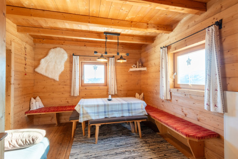 Træinteriør i en chalet ved navn Almhütte Nase i Østrig, hyggelig spiseplads og store vinduer.