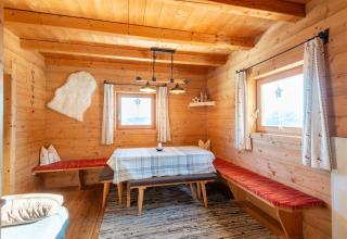 Træinteriør i en chalet ved navn Almhütte Nase i Østrig, hyggelig spiseplads og store vinduer.