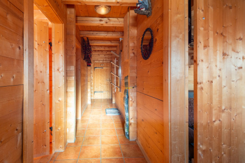 Træbeklædt gang med klinkegulv i chalet Almhütte Nase i Østrig, oplyst af naturligt lys og varmt interiør.