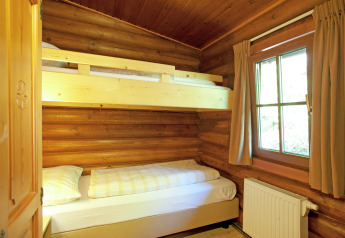 Cozy bedroom with bunk beds and wooden walls at Chalet Catharina im Brixental in Austria.