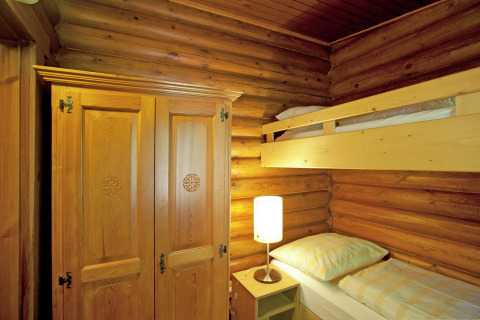 Room in Chalet Catharina im Brixental, Austria, featuring bunk beds, a wooden wardrobe, and log walls.