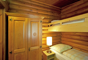 Room in Chalet Catharina im Brixental, Austria, featuring bunk beds, a wooden wardrobe, and log walls.