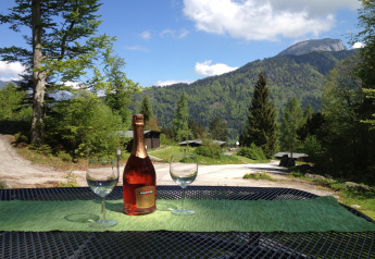 View from Chalet Catharina im Brixental in Austria with two glasses, a bottle and scenic mountains.