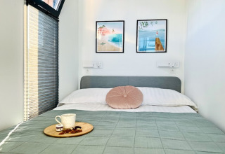 Gezellige slaapkamer op een woonboot in Denemarken met tweepersoonsbed, kunst en een koffieschotel.