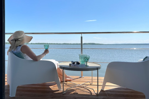 Vrouw ontspant op woonboot 'House on the water for 2 people' in Denemarken, genietend van het uitzicht.