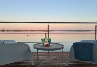 Uitzicht vanaf woonboot 'House on the water for 2 people' in Denemarken met wijn en rustig meer.