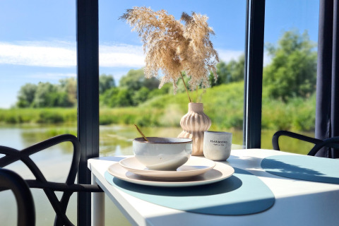 Beautiful table setup on the houseboat 'House on the water for 2 people' with nature and water views in Denmark.