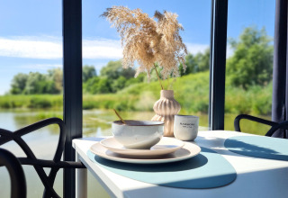 Beautiful table setup on the houseboat 'House on the water for 2 people' with nature and water views in Denmark.