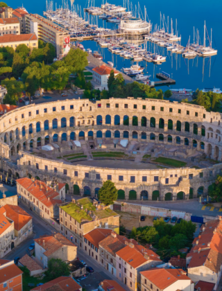 Luchtzicht op het Romeinse amfitheater in Pula dicht bij Rovinj, Istrië, Kroatië, met de jachthaven achteraan.