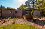 Moderno lodge con vasca idromassaggio coperta nel verde al Vakantiepark De Wiltzangh nei Paesi Bassi.