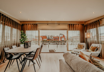 Intérieur lumineux de la péniche «Woude» à Marina Uitgeest, Pays-Bas, avec vue sur l’eau et fauteuils.
