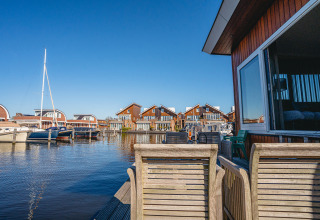View from houseboat ‘Woude’ at Marina Uitgeest, Netherlands, with boats and modern waterfront homes.