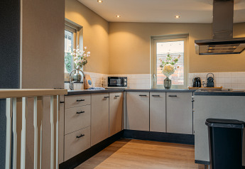 Moderne keuken op woonboot 'Woude' aan Marina Uitgeest in Nederland, met veel licht en strakke afwerking.