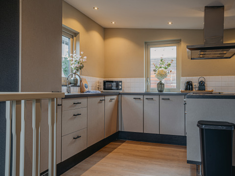 Cucina moderna della houseboat «Woude» alla Marina Uitgeest nei Paesi Bassi, con luci soffuse e decorazioni floreali.