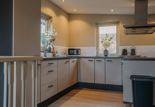 Cocina moderna en la casa flotante «Woude» en Marina Uitgeest, Países Bajos, con luz natural y decoración elegante.