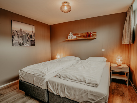 Chambre sur la péniche 'Woude' à Marina Uitgeest, Pays-Bas, avec deux lits et une décoration chaleureuse.