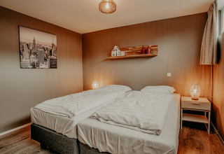 Chambre sur la péniche 'Woude' à Marina Uitgeest, Pays-Bas, avec deux lits et une décoration chaleureuse.