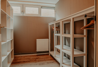Lyst og moderne walk-in-closet ombord på husbåden Woude ved Marina Uitgeest i Holland.