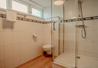 Moderne badkamer op woonboot «Woude» aan Marina Uitgeest, Nederland, met glazen douche en hangtoilet.