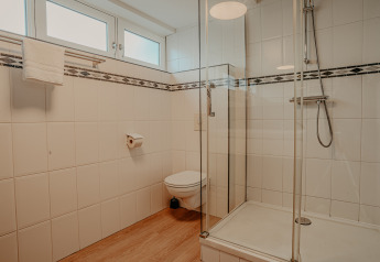 Modernes Badezimmer auf Hausboot «Woude» bei Marina Uitgeest, Niederlande, mit Glasdusche und Hängetoilette.