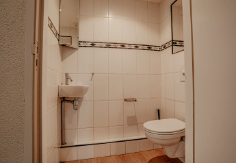 Moderne badkamer op woonboot in Marina Uitgeest, Nederland, met zwevend toilet en klein wasbakje.