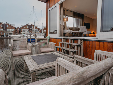 Terrazza in legno con sedute sulla Houseboat 'Woude' alla Marina Uitgeest, Paesi Bassi, vista interna.