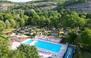 Vista aérea de Dordogne Deluxe en La Draille, Francia, con piscina, cabañas y abundante vegetación verde.