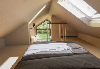 Dormitorio en ático del lodge Dordogne Deluxe en La Draille, Francia, con tragaluz y cama cómoda de matrimonio.