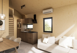 Interior moderno de una cabaña con cocina, mesa, sofá y escalera en Dordogne Deluxe en La Draille, Francia.