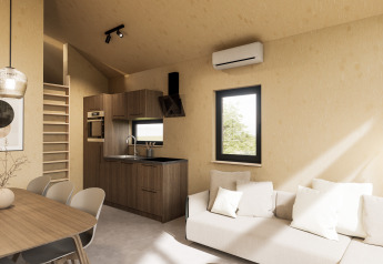 Modernes Lodge-Interieur mit Küche, Esstisch, Sofa und Leiter im Dordogne Deluxe bei La Draille, Frankreich.