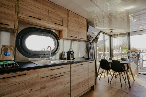 Modernes Hausboot Campi in der Marina Uitgeest, Küche und Essbereich mit Blick aufs Wasser.