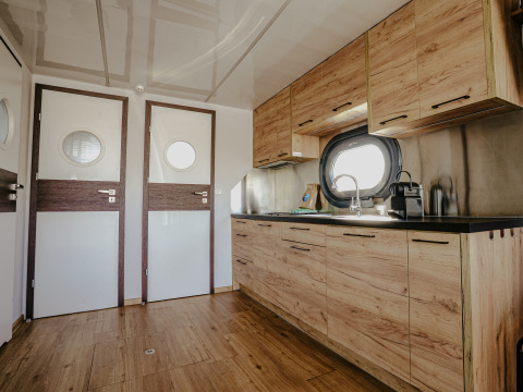 Moderne køkkeninteriør på husbåden ‘Campi’ ved Marina Uitgeest, Nederlandene, med træfinish.