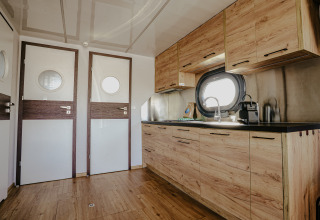 Moderne køkkeninteriør på husbåden ‘Campi’ ved Marina Uitgeest, Nederlandene, med træfinish.