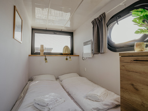 Dormitorio en la casa flotante Campi en Marina Uitgeest, Países Bajos, con dos camas individuales.