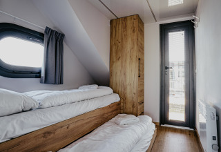 Hyggeligt soveværelse med køjesenge og træskab på husbåd «Campi» ved Marina Uitgeest, Holland.