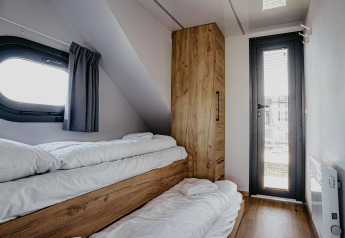 Gemütliches Schlafzimmer mit Etagenbett und Holzschrank auf dem Hausboot «Campi» in Marina Uitgeest.