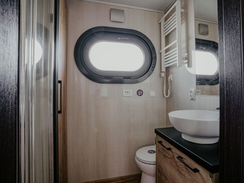 Bagno moderno sulla houseboat 'Campi' con oblò, lavabo e wc presso Marina Uitgeest, Paesi Bassi.