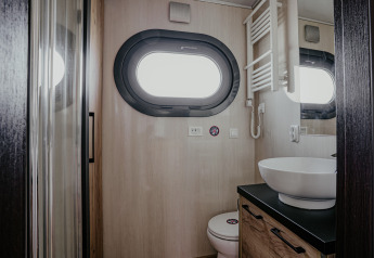 Bagno moderno sulla houseboat 'Campi' con oblò, lavabo e wc presso Marina Uitgeest, Paesi Bassi.