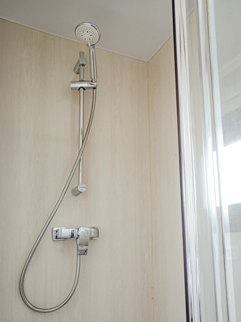 Bruser på badeværelset i husbåden Campi ved Marina Uitgeest, Holland, moderne design og glasdør.