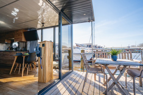 Innenraum und Terrasse des Hausboots 'Campi' in der Marina Uitgeest, Niederlande, mit Blick auf den Hafen.