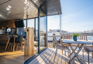 Vue intérieure et terrasse du houseboat « Campi » à Marina Uitgeest, Pays-Bas, surplombant le port de plaisance.