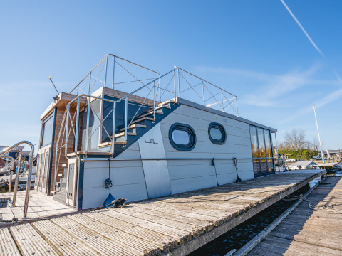 Das moderne Hausboot „Campi“ liegt bei sonnigem Wetter im Yachthafen Uitgeest in den Niederlanden.