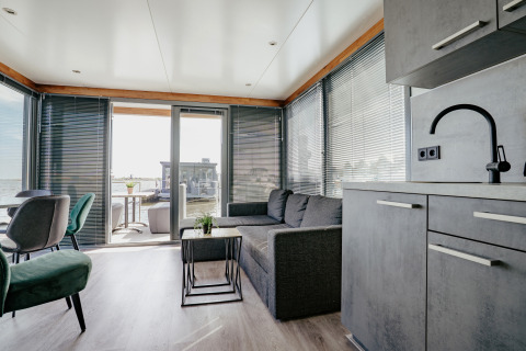 Modern living room inside Houseboat 'Havenlodge' at Marina Uitgeest in the Netherlands with water view.